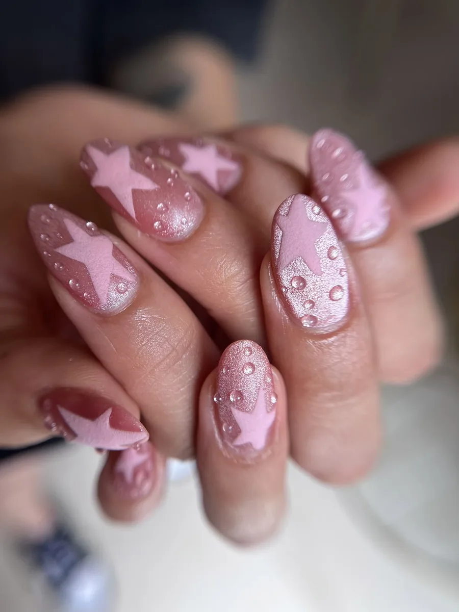 Uñas almendradas en rosa perlado con estrellas mate y perlitas en relieve