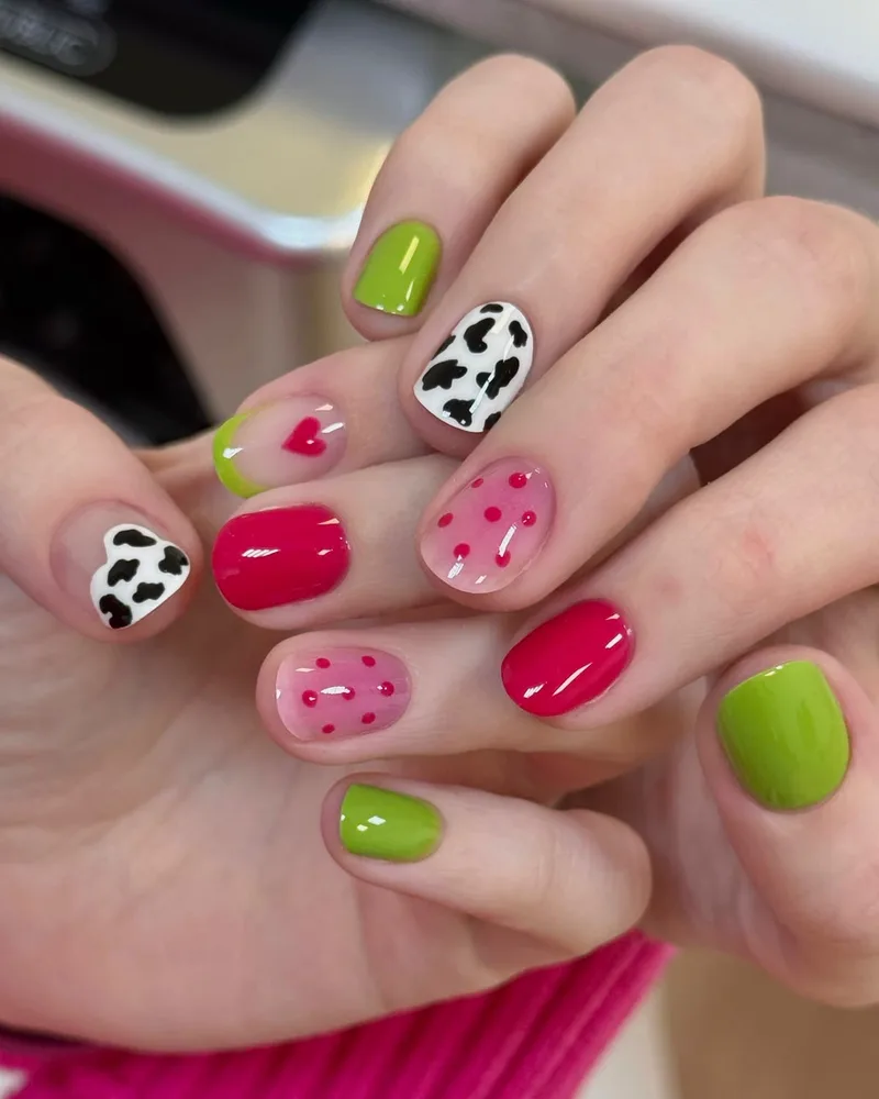 Uñas cortas multicolor con corazones, lunares y print de vaca, hechas en el estudio